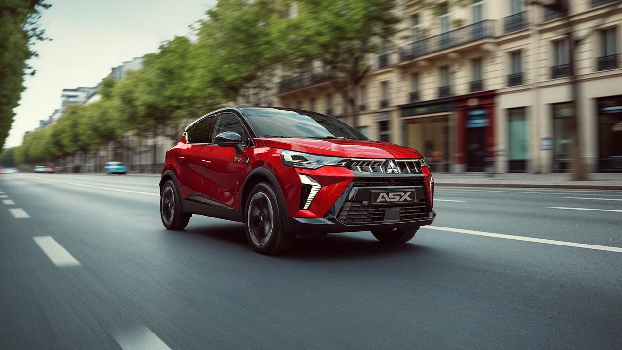 Mitsubishi ASX vermelho em andamento numa avenida com árvores