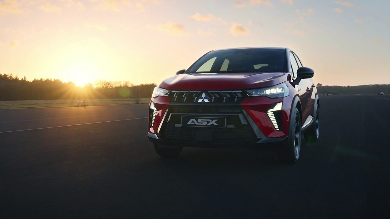 Mitsubishi ASX vermelho de frente, numa pista ao pôr do sol