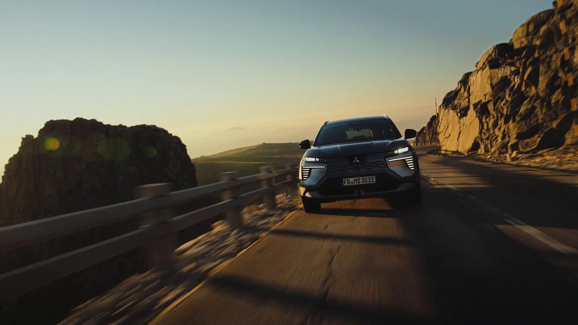 Mitsubishi Eclipse Cross EV cinzento numa estrada de montanha ao fim da tarde