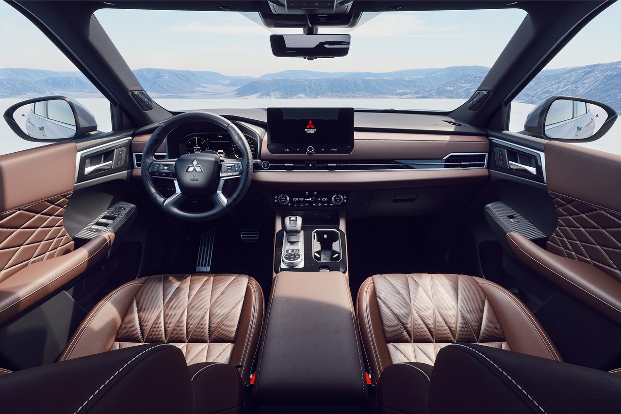 Habitáculo do Outlander PHEV visto de trás, com os bancos em pele castanha, o volante e o ecrã central