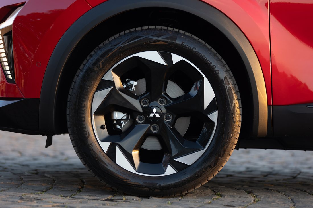 Roda dianteira de um Mitsubishi ASX vermelho, com a jante vista de perto