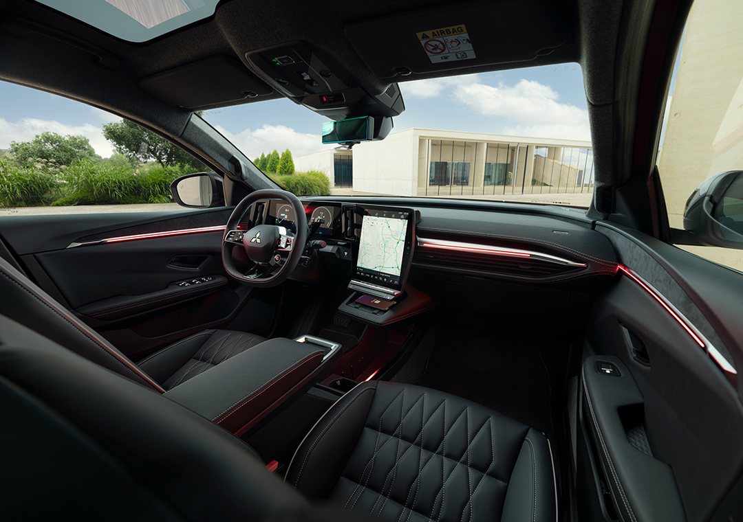 Habitáculo do Mitsubishi Eclipse Cross EV visto do banco de trás, com a luz ambiente acesa ao longo do painel