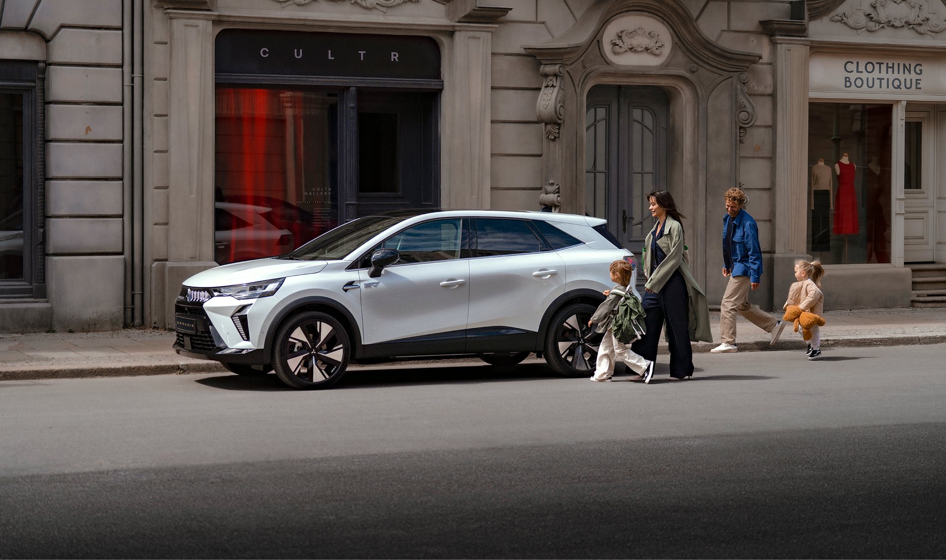 Mitsubishi Grandis branco estacionado numa rua, com uma família a passar no passeio